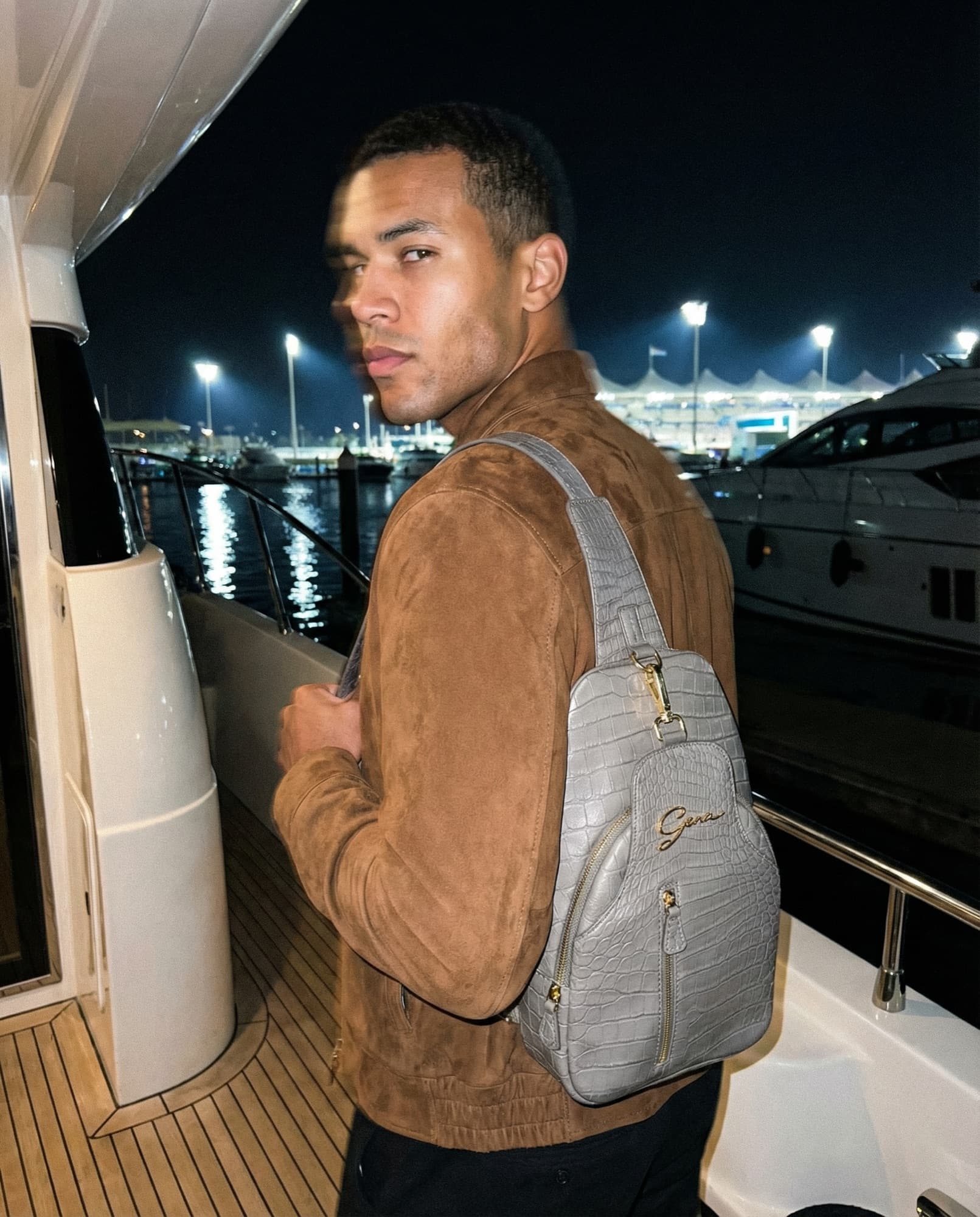 Gray sling bag carried on a yacht at night